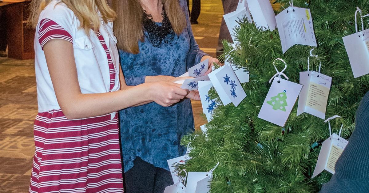 Chloe Hall and her mom, Patti, select individuals to buy Christmas gifts for as part of their church’s Giving Tree of Hope program.