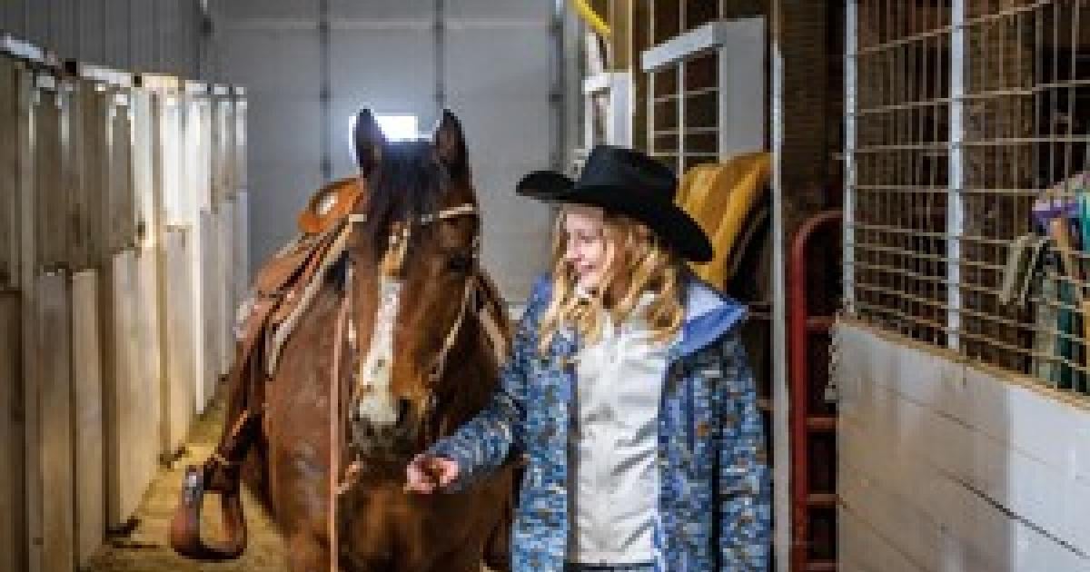 Kenney Lyson guides her horse, Gracie, through the family barn in Baker, Mont. (PHOTO BY JOHN KARY/NDAREC