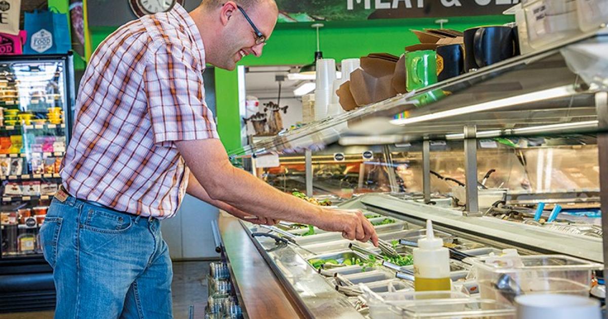 Local products constitute 80 percent of the BisMan Community Food Co-op’s fresh salad bar, which member-owner Paul Breiner enjoys over lunch.
