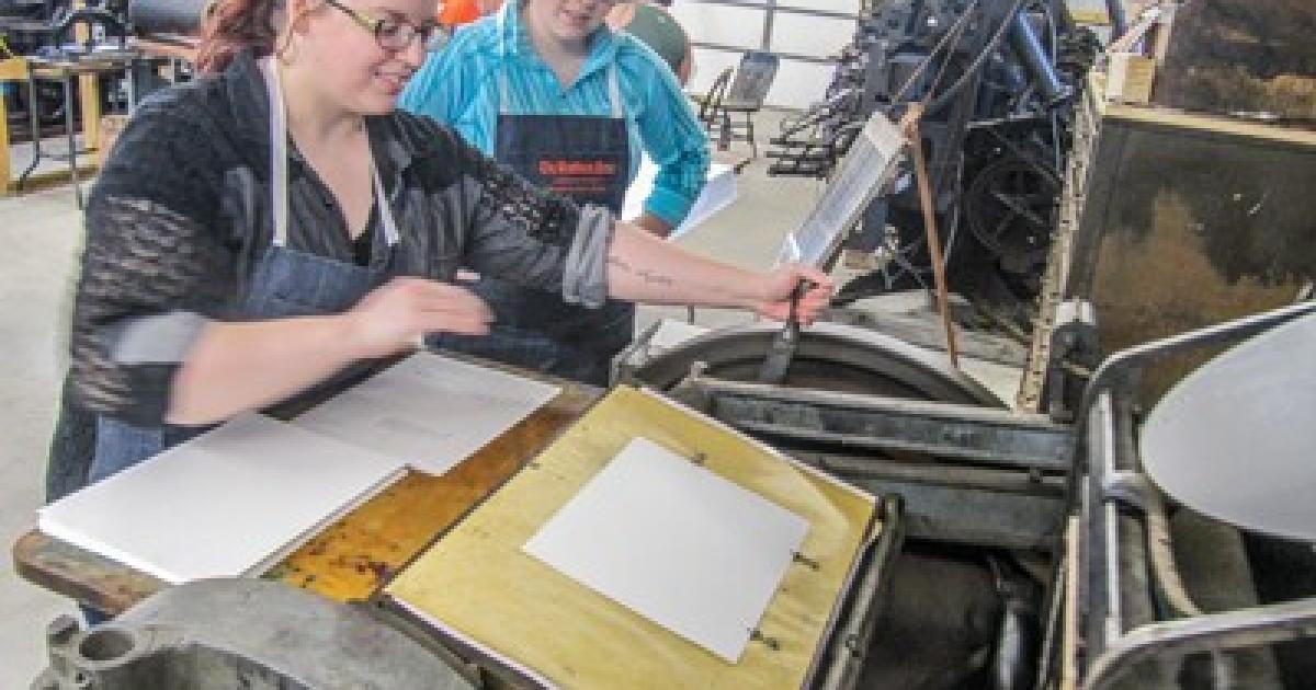 Students operate the letterpress at the Braddock museum.