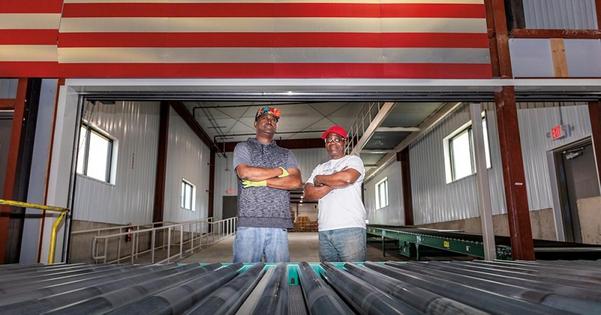 Co-workers Abdirahim Ahmed and Henry Bajebo at work on the manufacturing floor. Photo by NDAREC/Liza Kessel