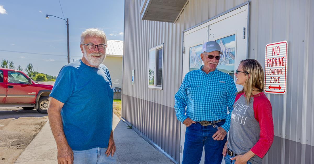 Bob Martin, left, and Corey Hart, directors on the Bowdon Meat Processing cooperative board, check in with their co-op manager, Laura Eide, outside the meat plant.