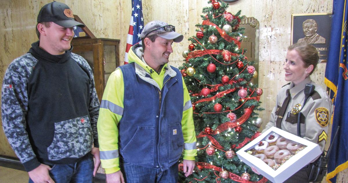 Donuts! “What better way to say thank you,” Renville County Sheriff’s Deputy Ann Millerbernd thought, than bringing donuts to North Central Electric Cooperative lineworkers, Talon Thompson, left, and Randy McLean, whom she credits with saving her life last fall. PHOTO BY PETE ERICKSON/NORTH CENTRAL ELECTRIC COOPERATIVE