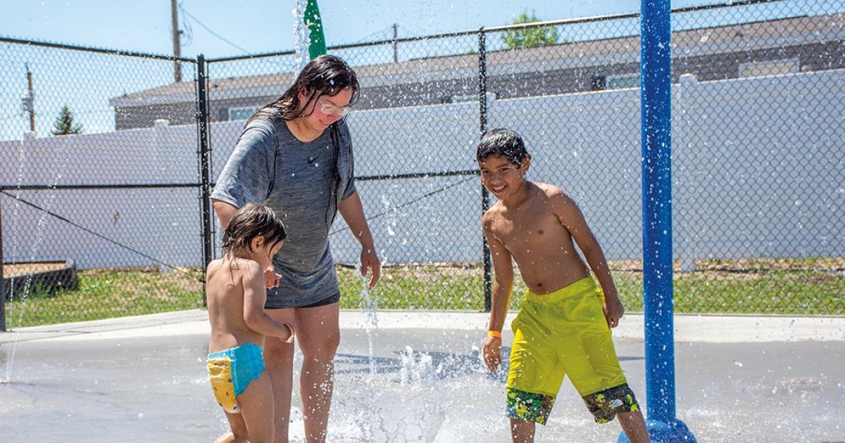 Lucy Fox and her sons, Isaak Larrison, left, and Keon Phommohaxay cool off at the New Town Water Park. PhotoS by NDAREC/John Kary