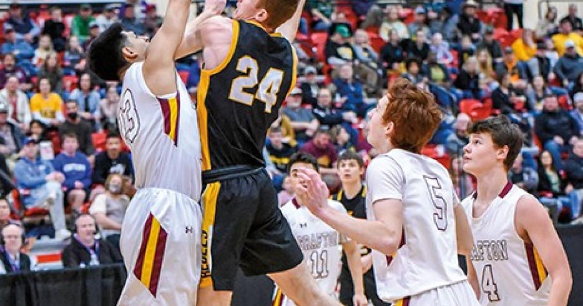 Edgeley/Kulm/Montpelier's Alex Huber (24) lays one up against Grafton defenders in the semifinal game of the 2021 North Dakota State Class B Boys Basketball Tournament. Huber and the Rebels went on to win the game by three points, earning a place in the state championship game. Photo courtesy Rhonda Tjernlund/Tjernlund Photography