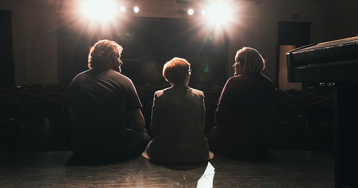 Dakota Prairie Regional Center for the Arts Creative Director Elliott Schwab, from left, Managing Director Deb Belquist and Assistant Managing Director Erin Greiner sit on the stage at the Old Church Theatre. Photos by NDAREC/Liza Kessel