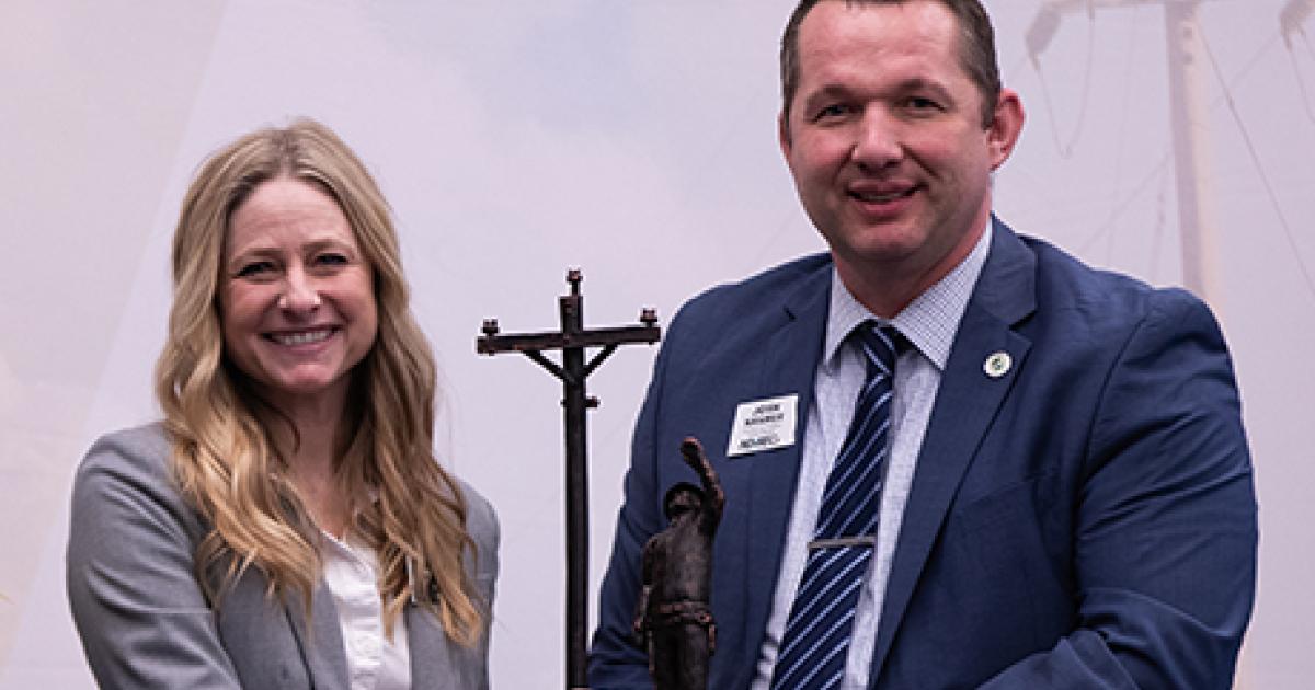 Rep. Anna Novak accepts the Helping Hand Award from NDAREC’s Josh Kramer.