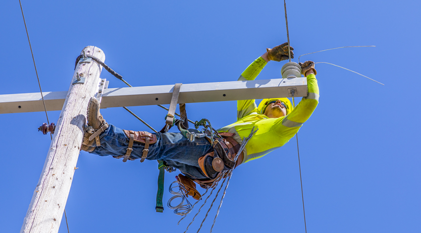 Brad Schmitt, an apprentice line technician with Slope Electric Cooperative, repairs a damaged power line near Crosby May 4.
